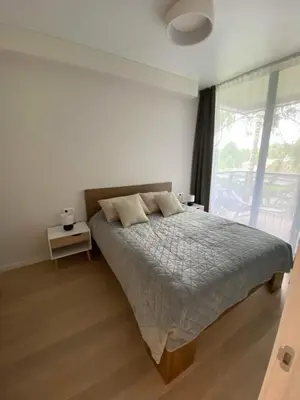 a bedroom with a bed and a large window at Apartment-Pine Forest Birštonas in Birštonas