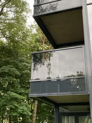 a glass facade of a building with trees in the background at Apartment-Pine Forest Birštonas in Birštonas