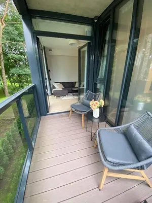 a screened porch with chairs and a couch on a house at Apartment-Pine Forest Birštonas in Birštonas