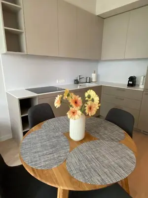 a kitchen with a table with a vase of flowers on it at Apartment-Pine Forest Birštonas in Birštonas