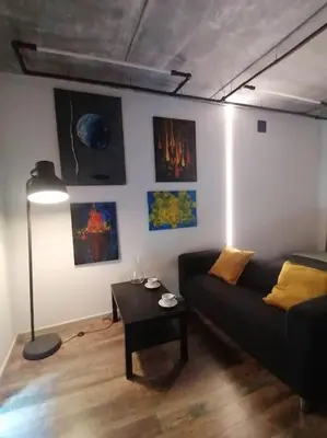 a living room with a couch and a table at Erdvi studija Spacious studio apartment Self check in in Vilnius
