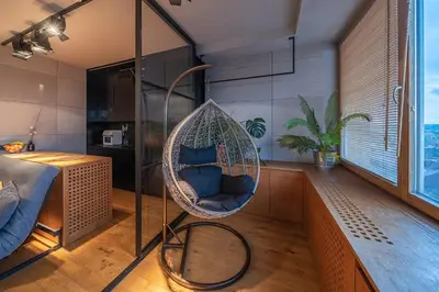a hanging chair in a room with a window at Vivulskio Apartament - Lollo Stay in Vilnius
