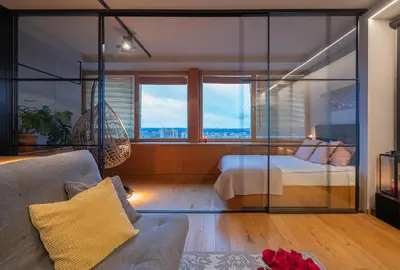 a room with a bed and a couch and windows at Vivulskio Apartament - Lollo Stay in Vilnius