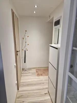 a room with a white refrigerator and a hallway at VYTAUTO 3 apartment in Ukmergė