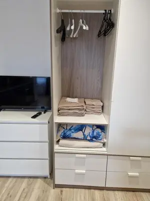 a closet with white drawers and a tv at VYTAUTO 3 apartment in Ukmergė