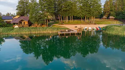 a view of a lake with a house and a dock at Vila Ula in Perloja