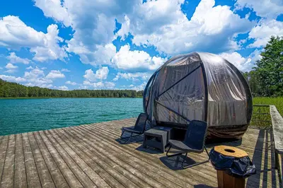 a dome tent sitting on a dock next to a body of water at Vila Ula in Perloja