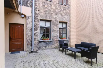 a patio with chairs and a table and a building at Cosy and authentic apartment in Vilnius Old Town in Vilnius