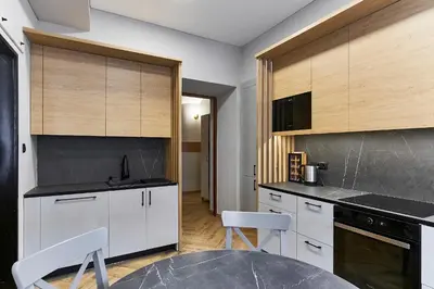 a kitchen with white cabinets and a table and chairs at Cosy and authentic apartment in Vilnius Old Town in Vilnius