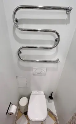 a bathroom with a toilet and two grab bars at Stilingi šaulio skulptūros apartamentai in Druskininkai