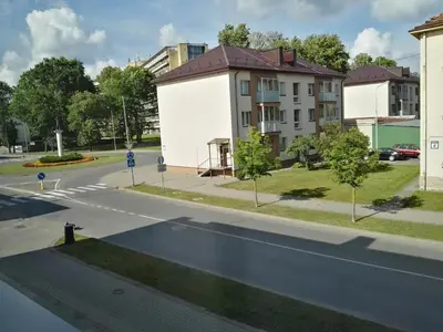 an empty street in a city with a building at Stilingi šaulio skulptūros apartamentai in Druskininkai