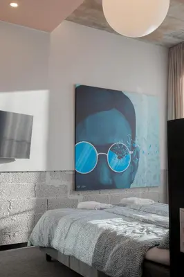 a painting of a person wearing sunglasses on a wall at Resume apartments in Kaunas