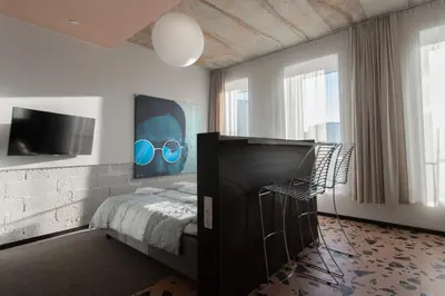 a bedroom with a bed and a tv on the wall at Resume apartments in Kaunas