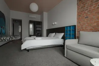 a bedroom with a bed and a couch at Resume apartments in Kaunas