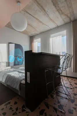 a bedroom with a bed with a mirror and two chairs at Resume apartments in Kaunas