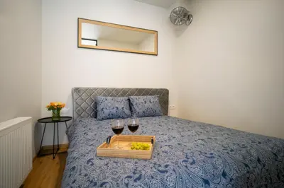 a bed with a tray with two glasses of wine at Fort63 house in Kaunas