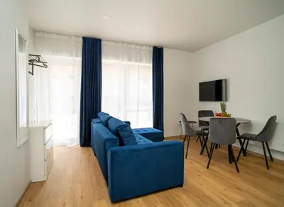 a living room with a blue couch and a table at Fort63 house in Kaunas