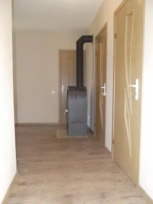 an empty room with a stove in the middle at Nakvynė Rokiškyje in Rokiškis
