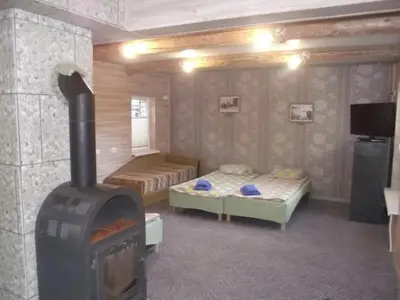 a room with two beds and a wood stove at Nakvynė Rokiškyje in Rokiškis