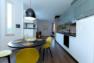 a kitchen with a black table and yellow chairs at Vilnius Apartments & Suites - Gedimino avenue in Vilnius