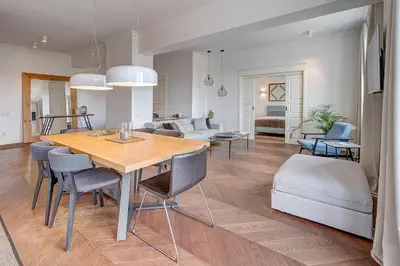 a dining room and living room with a table and chairs at Vilnius Apartments & Suites - Gedimino avenue in Vilnius