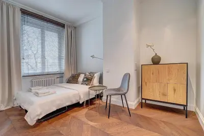 a bedroom with a bed and a chair and a table at Vilnius Apartments & Suites - Gedimino avenue in Vilnius