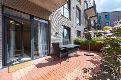 a patio with a table and chairs in front of a building at Paupys Central Apartments by Reside Baltic in Vilnius