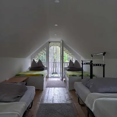 a room with three beds and a window at Ramintos miško namelis in Žiogeliai