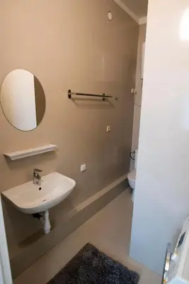 a bathroom with a sink and a mirror and a toilet at Main Street Šiauliai, City Center in Šiauliai