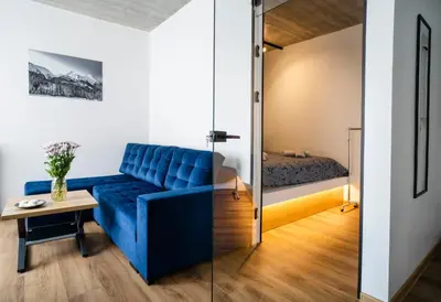 a blue couch in a room with a bed at Fort63 apartments in Kaunas
