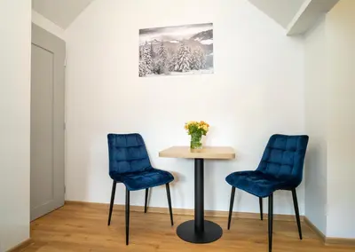 two blue chairs and a table in a room at Fort63 apartments in Kaunas