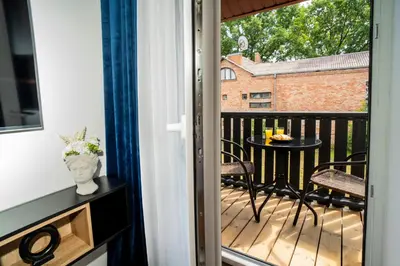 a balcony with a table and chairs on a deck at Fort63 apartments in Kaunas