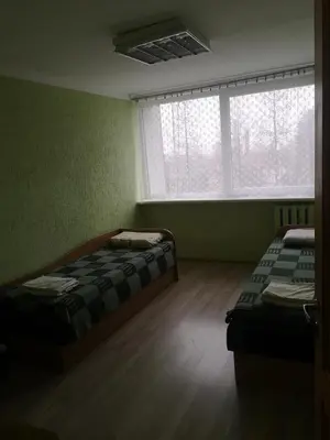 a room with two beds and two windows at Kambarių nuoma Žeimelyje in Žeimelis
