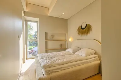 a bedroom with a bed and a window at Apartamentai Astra in Druskininkai