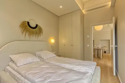 a bedroom with a bed with white sheets at Apartamentai Astra in Druskininkai
