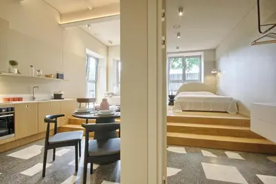 a kitchen and living room with a bed and a table at Apartamentai Astra in Druskininkai