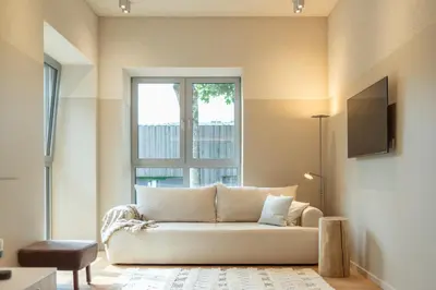 a living room with a couch and a window at Apartamentai Astra in Druskininkai