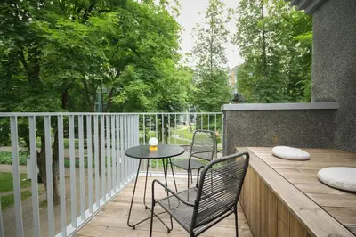 a patio with a table and chairs on a deck at Apartamentai Astra in Druskininkai