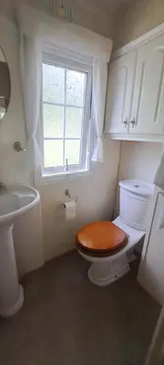 a bathroom with a toilet and a sink and a window at Namelis po beržais in Marijampolė