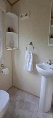 a bathroom with a sink and a white towel at Namelis po beržais in Marijampolė