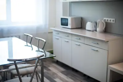 a kitchen with a table and chairs and a microwave at V 13 - 3 BDR Balcony, Views - Courtyard n Vokiečių in Vilnius