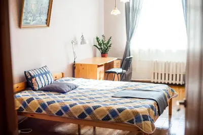 a bedroom with a bed and a desk and a window at V 13 - 3 BDR Balcony, Views - Courtyard n Vokiečių in Vilnius
