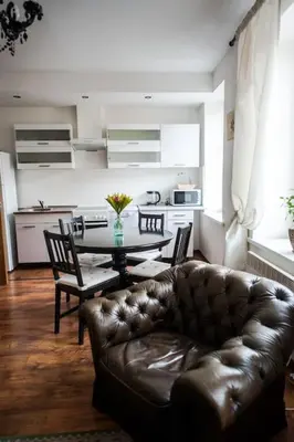 a living room with a table and a leather couch at V 18 - Superior & Great views to Vokieciu street in Vilnius