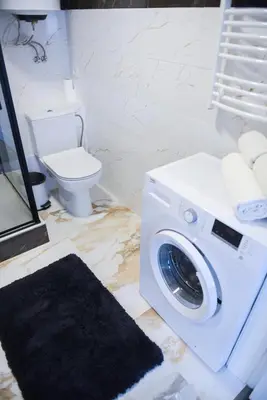 a washing machine in a bathroom with a toilet at Romantic New 1 Bedroom Vilnius Best Location in Vilnius