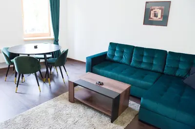 a living room with a green couch and a table at Romantic New 1 Bedroom Vilnius Best Location in Vilnius