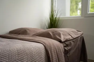 a bed with a blanket on it next to a window at Nordic Studio In Prime Vilnius Location in Vilnius
