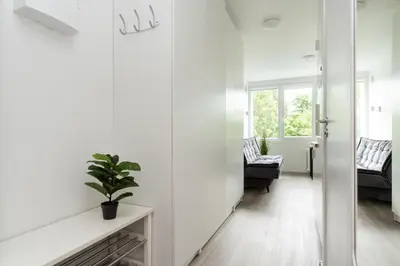 a living room with white walls and a plant on a table at Nordic Studio In Prime Vilnius Location in Vilnius