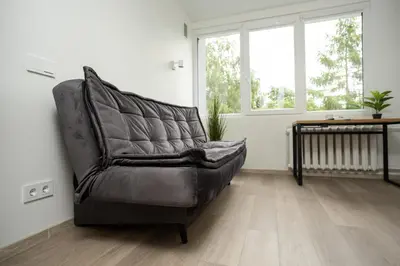 a leather chair in a living room with a table at Nordic Studio In Prime Vilnius Location in Vilnius