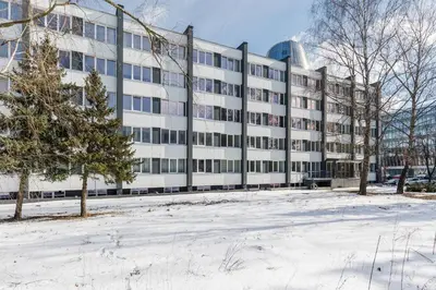 an office building with snow in front of it at Nordic Studio In Prime Vilnius Location in Vilnius
