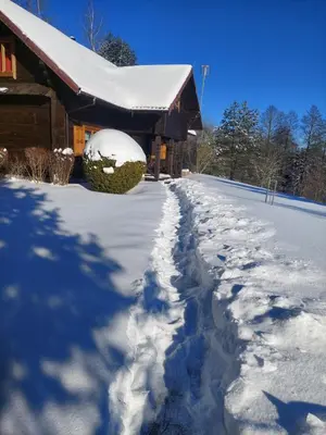 a snow covered path next to a house at Vila Mera in Pabradė